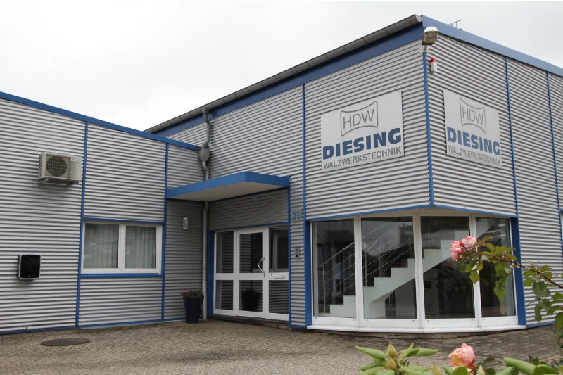 Außenansicht des Firmengebäudes von HDW Diesing Walzwerkstechnik mit moderner Metallfassade und klarer Beschilderung – repräsentativer Unternehmensstandort im Industriegebiet.